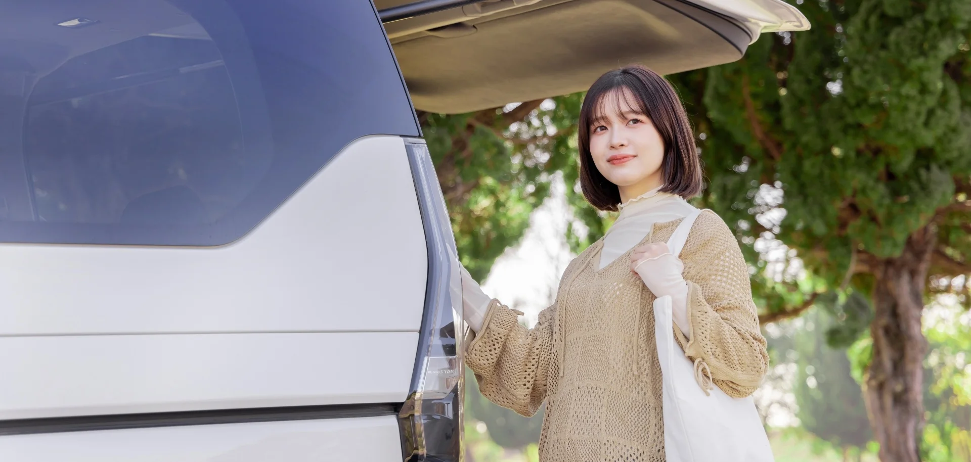 車のそばに立つペーパードライバー講習受講者のイメージ
